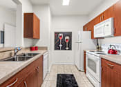 Thumbnail 7 of 71 - A kitchen with white appliances and wooden cabinets.