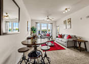 Thumbnail 10 of 71 - A living room with a grey couch, a round table, and a red rug.