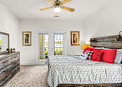 Thumbnail 14 of 71 - A bedroom with a bed, dresser, and ceiling fan.