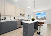Thumbnail 17 of 44 - A kitchen with a large island and a view of the city.