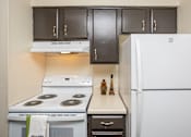 Thumbnail 4 of 19 - A kitchen with a white fridge, white stove and white oven.