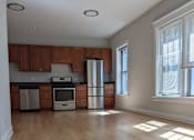 Thumbnail 4 of 19 - A kitchen with wooden cabinets and a refrigerator.