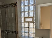 Thumbnail 8 of 19 - A bathroom with a white sink and a shower with a glass door.