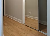 Thumbnail 12 of 19 - A white door is open in a room with wooden floors.