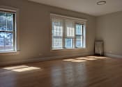 Thumbnail 13 of 19 - A room with wooden floors and two windows.