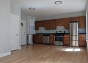 Thumbnail 1 of 19 - A kitchen with wooden cabinets and stainless steel appliances.