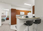 Thumbnail 20 of 71 - A kitchen with a counter and two chairs.