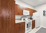 Thumbnail 21 of 71 - A kitchen with brown cabinets and white appliances.