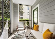 Thumbnail 32 of 71 - A white couch with two yellow pillows sits on a patio.