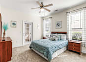 Thumbnail 26 of 71 - A bedroom with a bed, dresser, and ceiling fan.