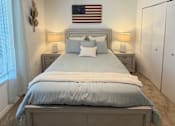 Thumbnail 47 of 48 - A bedroom with a large bed and an American flag on the wall.