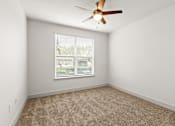 Thumbnail 26 of 50 - A room with a ceiling fan and a window with blinds.