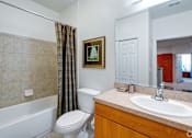 Thumbnail 39 of 71 - A bathroom with a white toilet, a white sink, a white bathtub, and a brown picture frame.