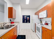 Thumbnail 41 of 71 - A kitchen with wooden cabinets and a fridge.