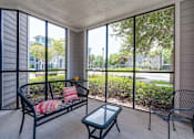 Thumbnail 50 of 71 - A patio with a black metal bench and a glass table.