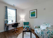 Thumbnail 48 of 71 - A room with a desk, chair, and couch.
