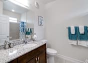 Thumbnail 43 of 71 - A bathroom with a white toilet and a sink.