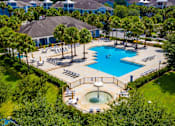 Thumbnail 42 of 44 - A large swimming pool surrounded by trees and a hot tub.