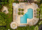 Thumbnail 4 of 71 - An aerial view of a swimming pool surrounded by trees and a patio area.