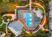 Thumbnail 36 of 50 - A pool surrounded by palm trees and a building.