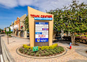 Thumbnail 43 of 50 - A sign for the Town Center at Cagan Crossing stands in front of a building.