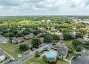 Thumbnail 23 of 24 - A bird's eye view of a residential area with houses, a swimming pool, and a parking lot.