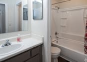 Thumbnail 7 of 24 - A white bathroom with a sink, toilet and bathtub.
