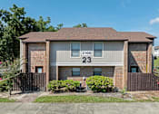 Thumbnail 1 of 24 - A house numbered 23100 is shown with a brown fence and green bushes.