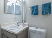Thumbnail 8 of 24 - A white sink with a pink soap and a white toilet in a bathroom.