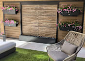 Thumbnail 11 of 16 - A patio with a chair, a bench, and flower pots.