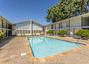 Thumbnail 5 of 12 - A swimming pool in a courtyard surrounded by apartment buildings.