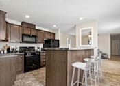 Thumbnail 1 of 14 - model kitchen with barstools  at Candlelight Village Manufactured Home Community in Sauk, IL