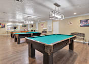 Thumbnail 22 of 23 - A pool table in a room with a light hanging from the ceiling.