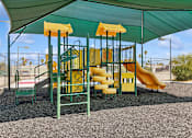 Thumbnail 22 of 23 - Playground with sun shade at Verde Plaza Manufactured Home Community in Tucson, Arizona
