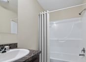 Thumbnail 7 of 14 - Model bathroom with tub and shower at Candlelight Village Manufactured Home Community in Sauk, IL