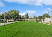 Thumbnail 12 of 14 - Tennis court with fence surrounding it at Candlelight Village Manufactured Home Community in Sauk, IL