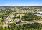 Thumbnail 3 of 8 - A bird's eye view of a suburban area with a mix of residential and commercial buildings surrounded by greenery.