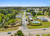 Thumbnail 1 of 8 - A road with cars and buildings on both sides.