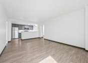 Thumbnail 14 of 45 - A spacious room with wooden flooring and white walls.