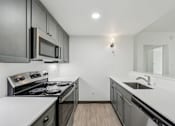 Thumbnail 33 of 45 - A modern kitchen with a stove top oven and microwave.