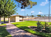 Thumbnail 8 of 23 - A small building sits in a grassy area with a walkway leading to it.