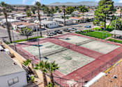 Thumbnail 5 of 23 - A tennis court surrounded by a fence and a residential area.