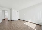 Thumbnail 20 of 45 - A room with white walls and wooden flooring with a rug in the middle.