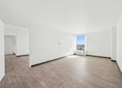 Thumbnail 22 of 45 - A large empty room with wooden floors and white walls.