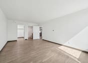 Thumbnail 32 of 45 - A room with wooden floors and white walls.