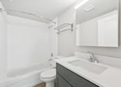 Thumbnail 13 of 45 - A white bathroom with a toilet, sink, and bathtub.