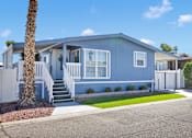 Thumbnail 2 of 23 - A blue house with a white fence and a palm tree in front.