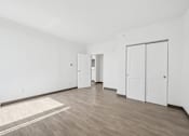 Thumbnail 30 of 45 - A room with white walls and wooden flooring with a rug on the floor.