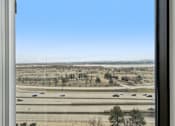 Thumbnail 11 of 45 - A view from a window looking out onto a highway with cars on it.