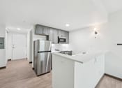 Thumbnail 35 of 45 - A kitchen with a stainless steel refrigerator and white cabinets.